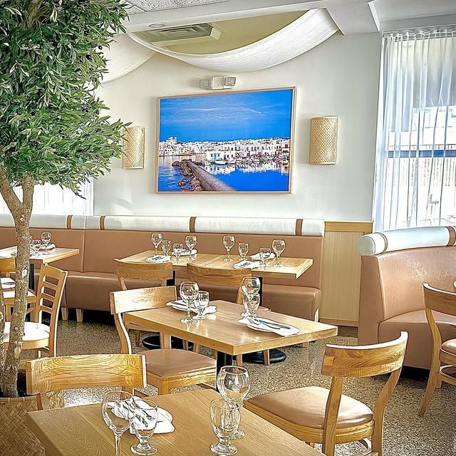 A restaurant with tables and chairs and a picture on the wall