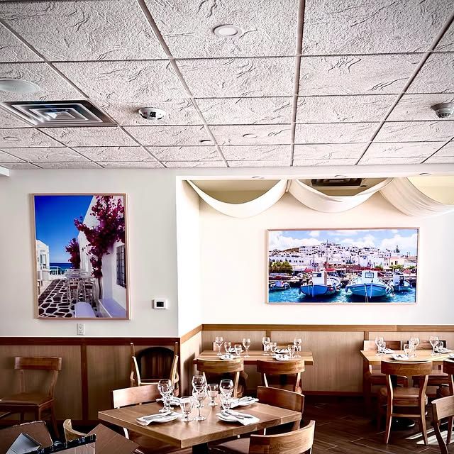 A restaurant with tables and chairs and two pictures on the wall