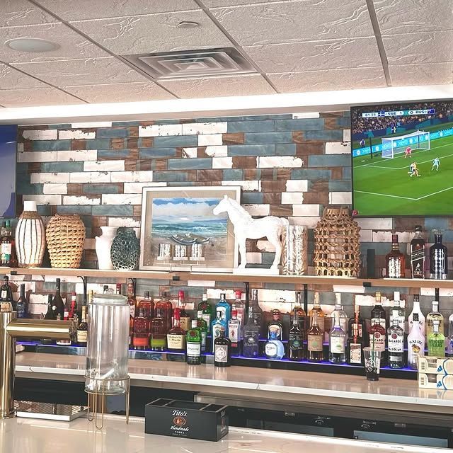 A bar with bottles of liquor and a tv on the wall