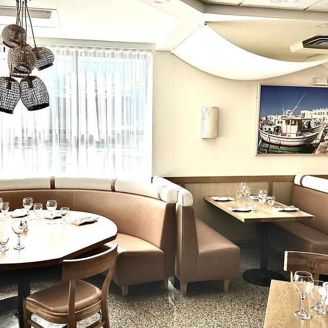 A restaurant with tables and chairs and a picture of a boat on the wall
