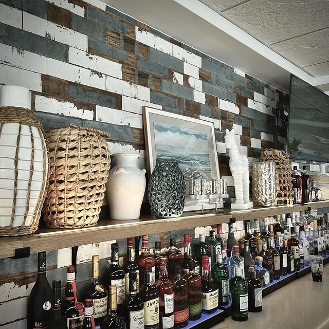 Many bottles of liquor are lined up on a bar