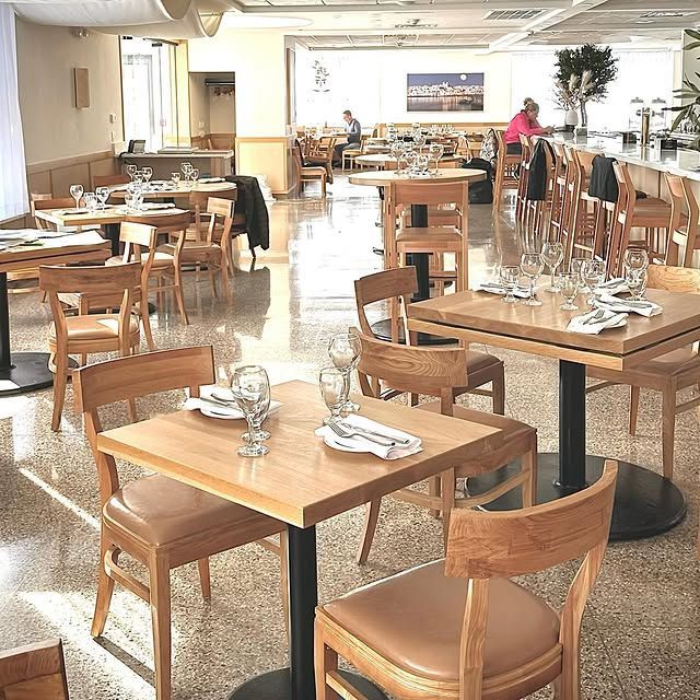 A restaurant filled with tables and chairs with plates and glasses on them