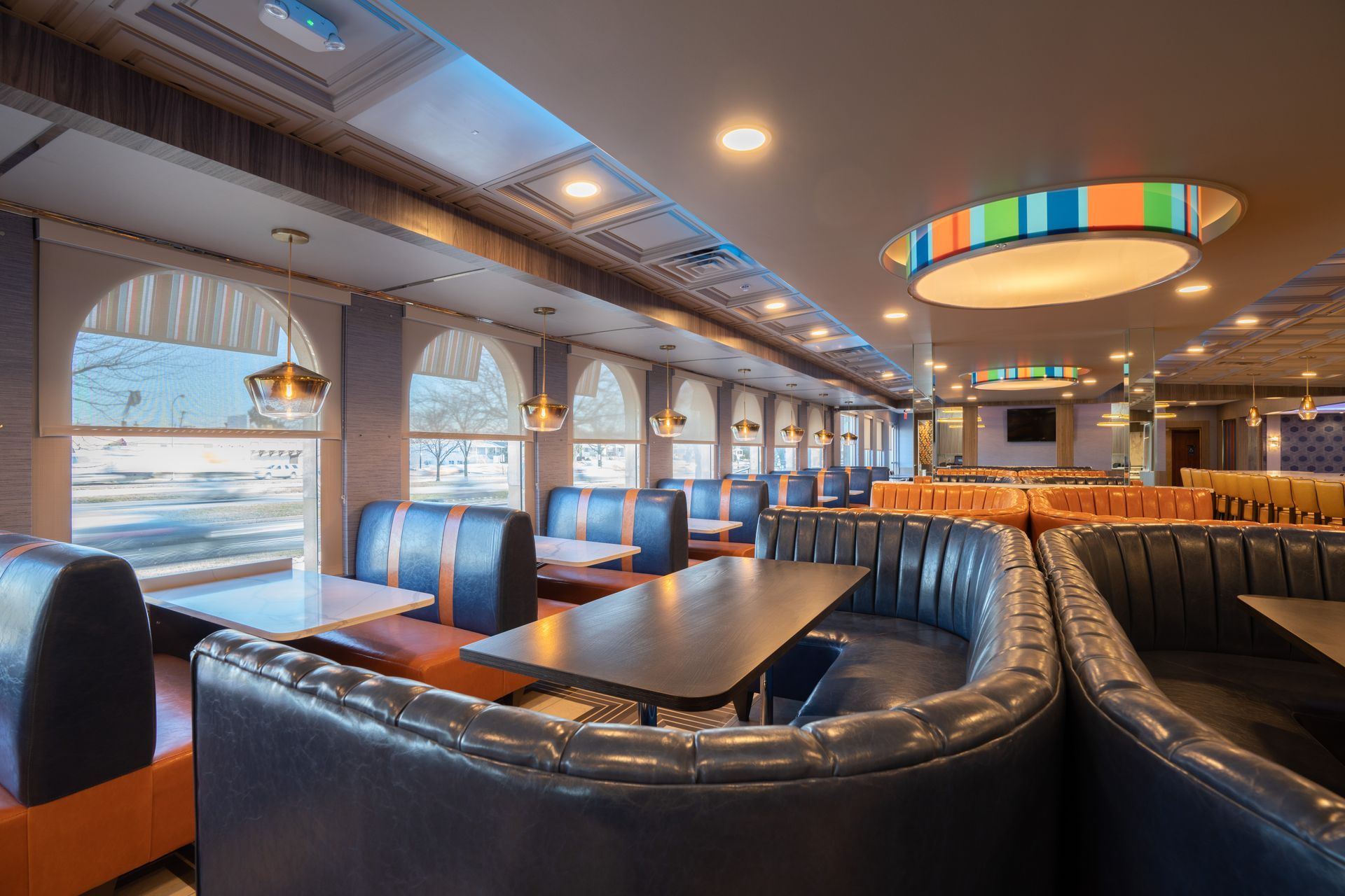 A restaurant with tables and chairs and a ceiling light.