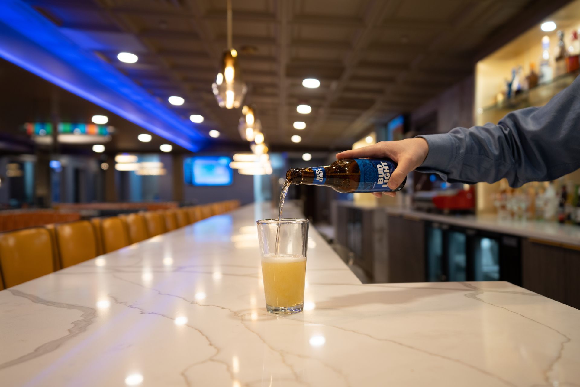 A person is pouring beer into a glass at a bar.
