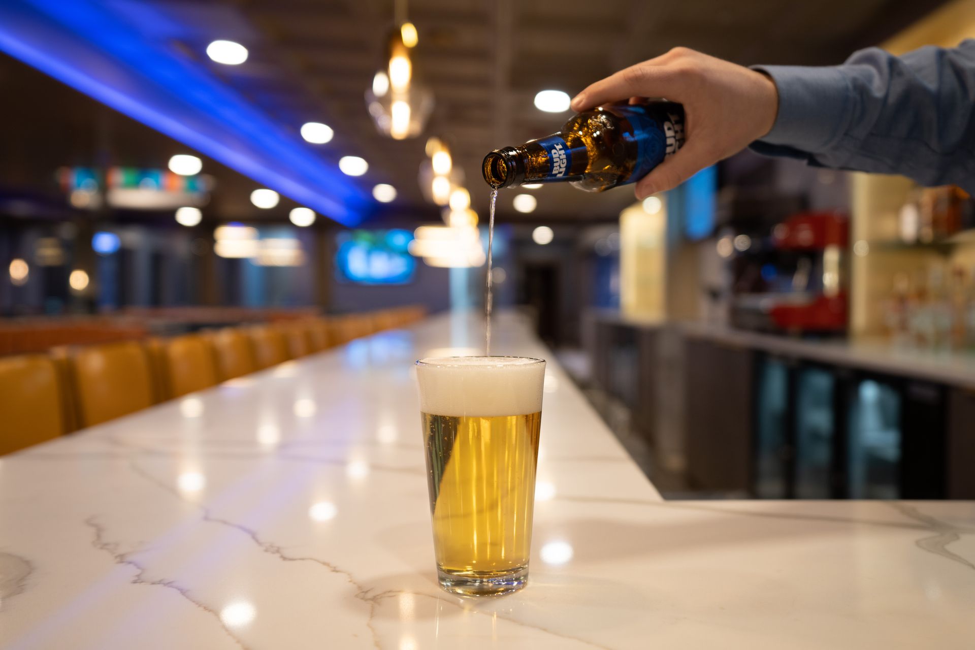 A person is pouring beer into a glass at a bar.