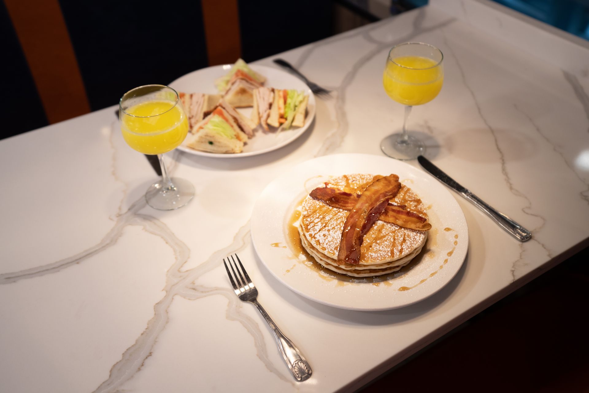 There is a plate of pancakes with bacon on it on the table.