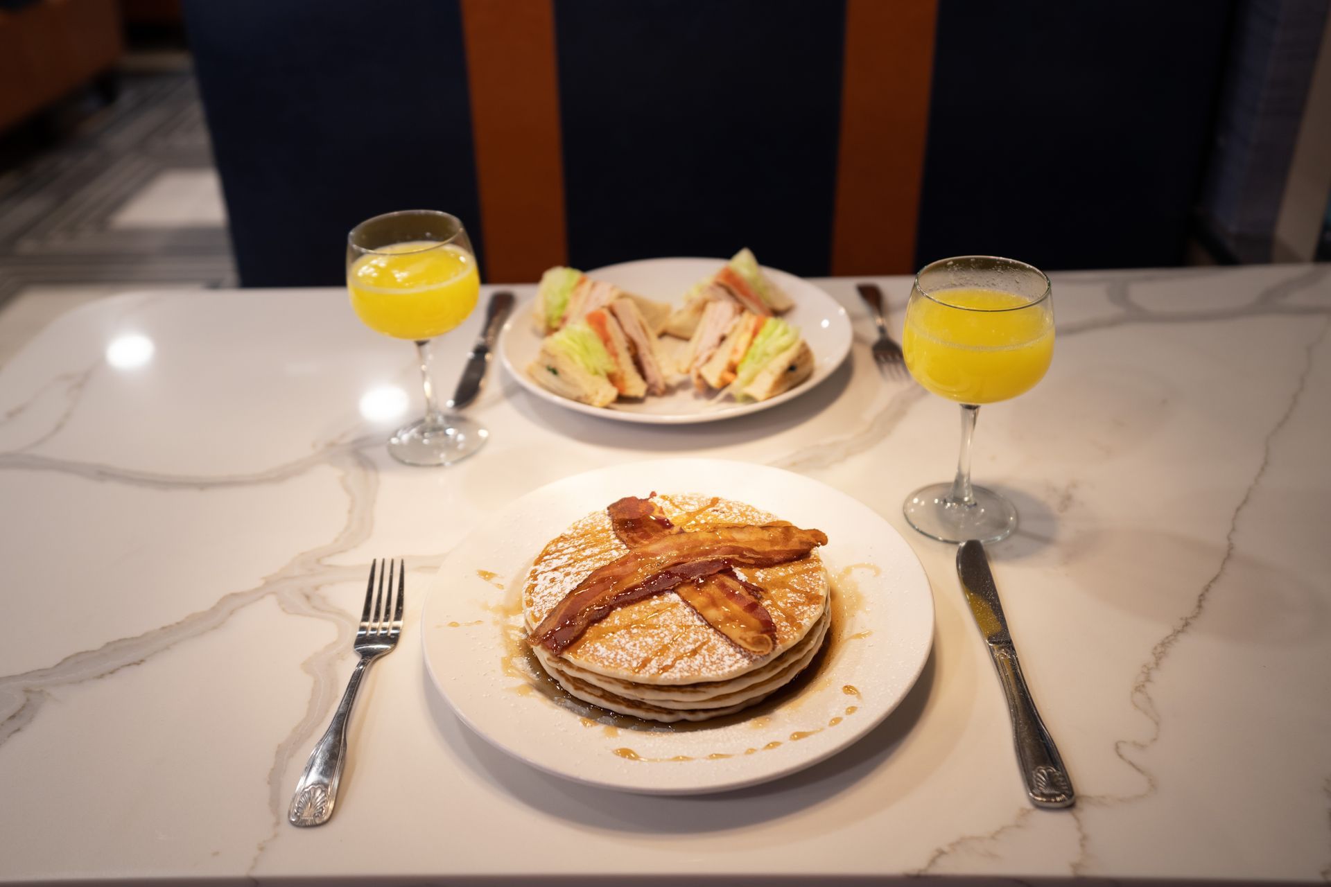 There is a plate of pancakes with bacon on it on the table.