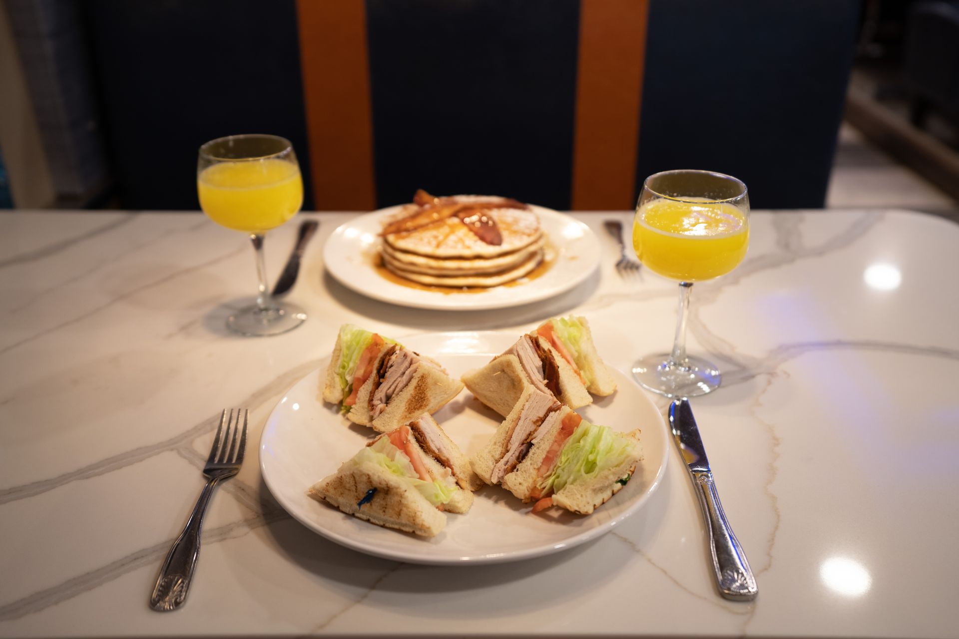 There is a plate of sandwiches and pancakes on the table.