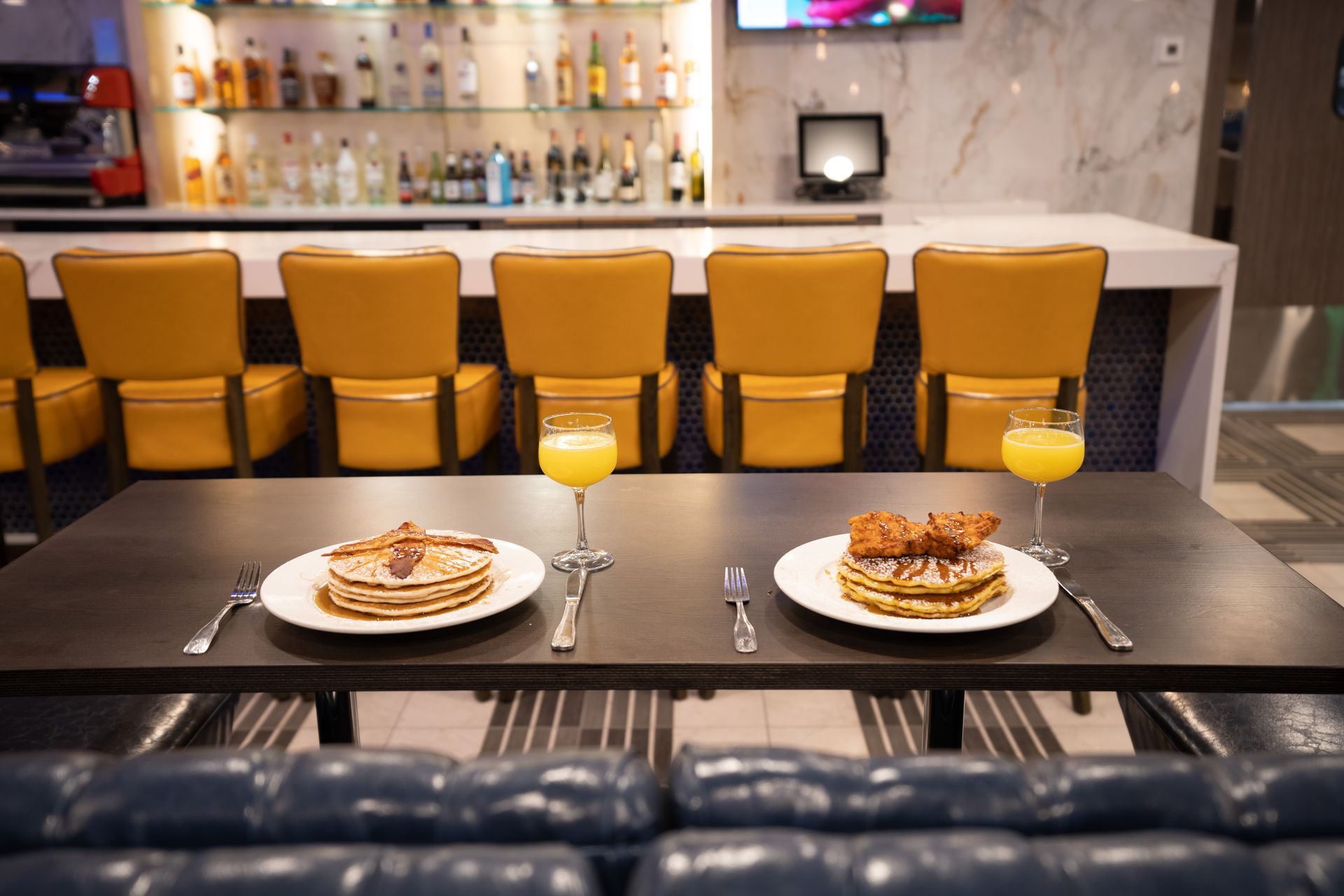 A table with two plates of food and a glass of orange juice.
