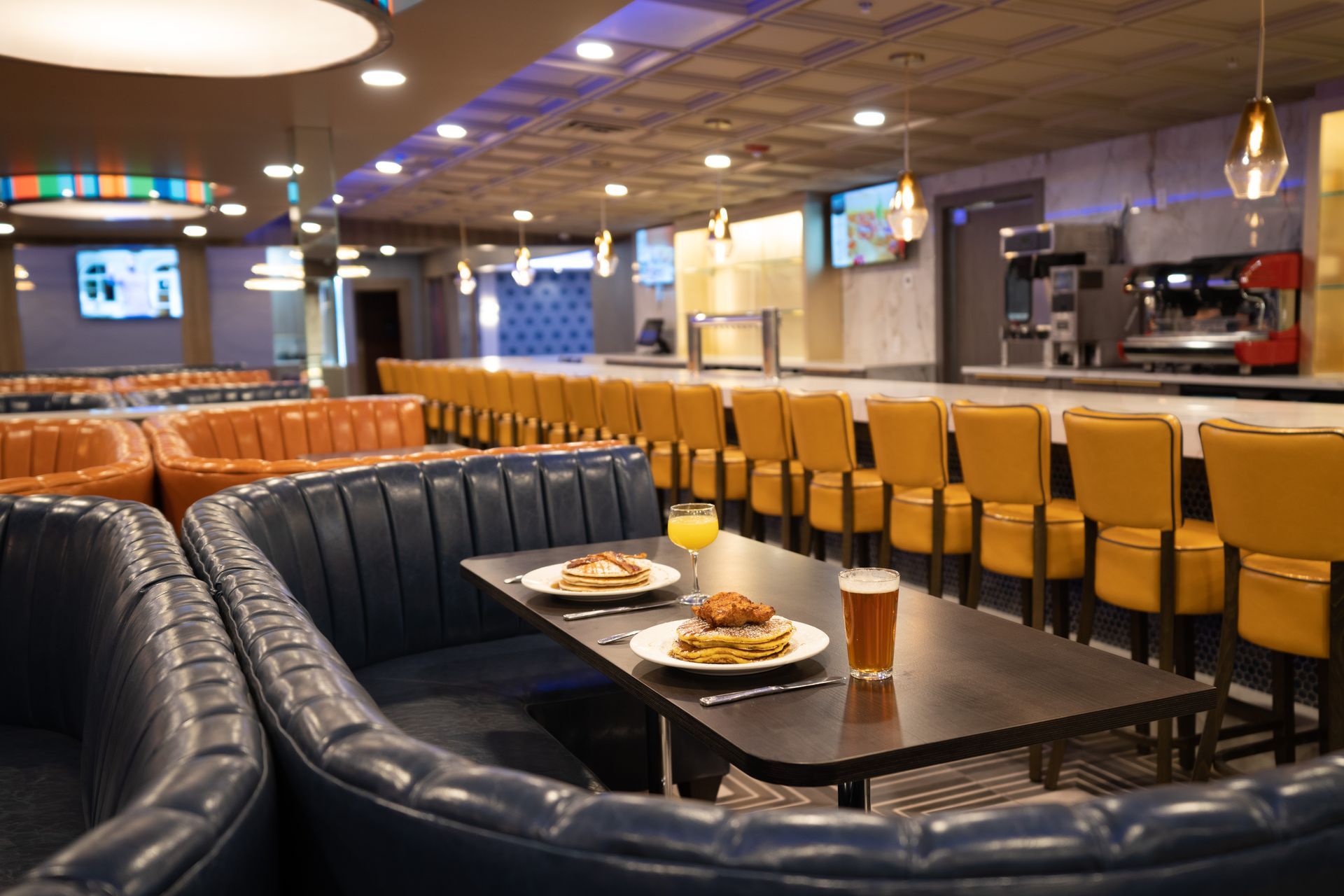 A restaurant with tables and chairs and plates of food on them.