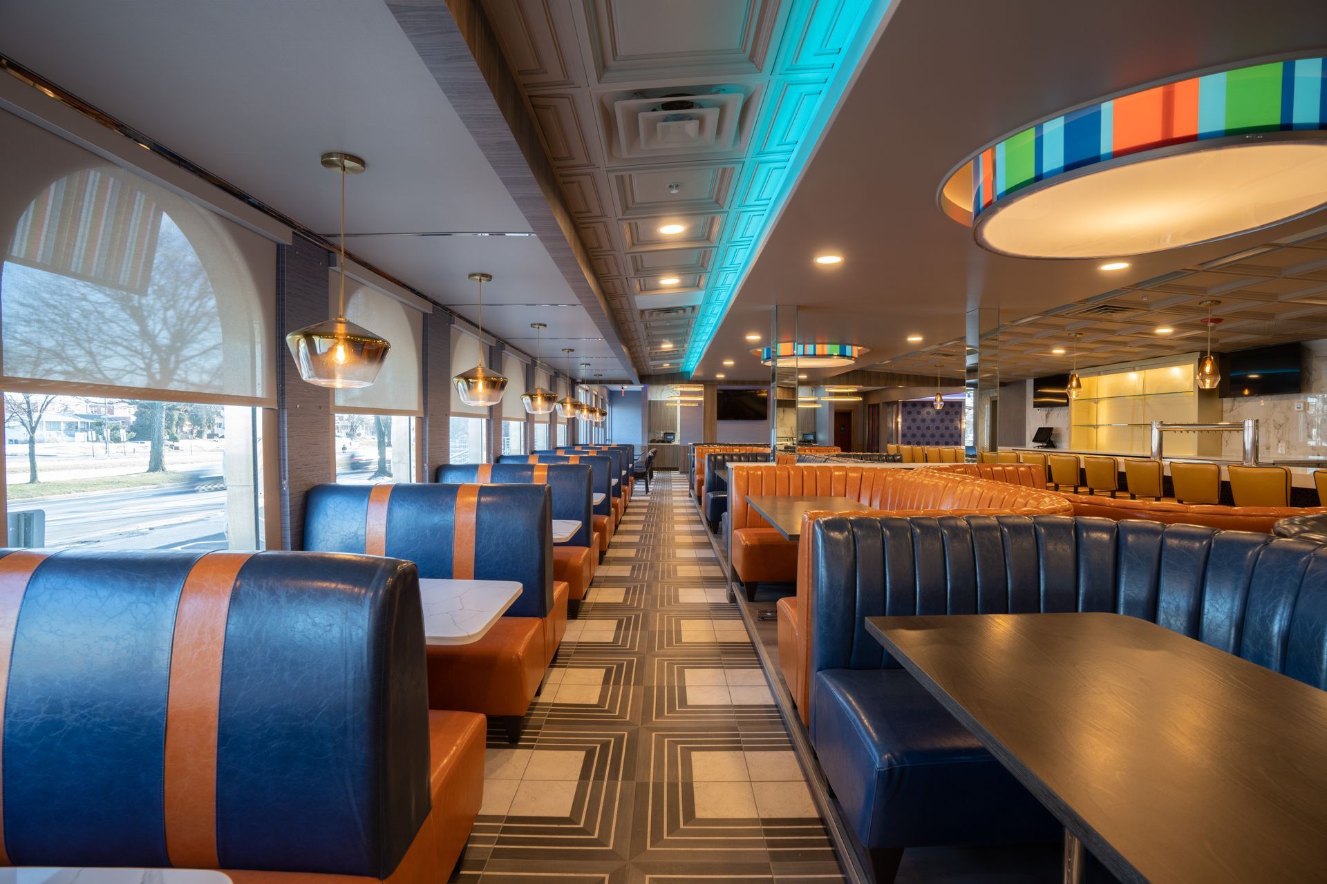 A diner with blue and orange booths and tables.