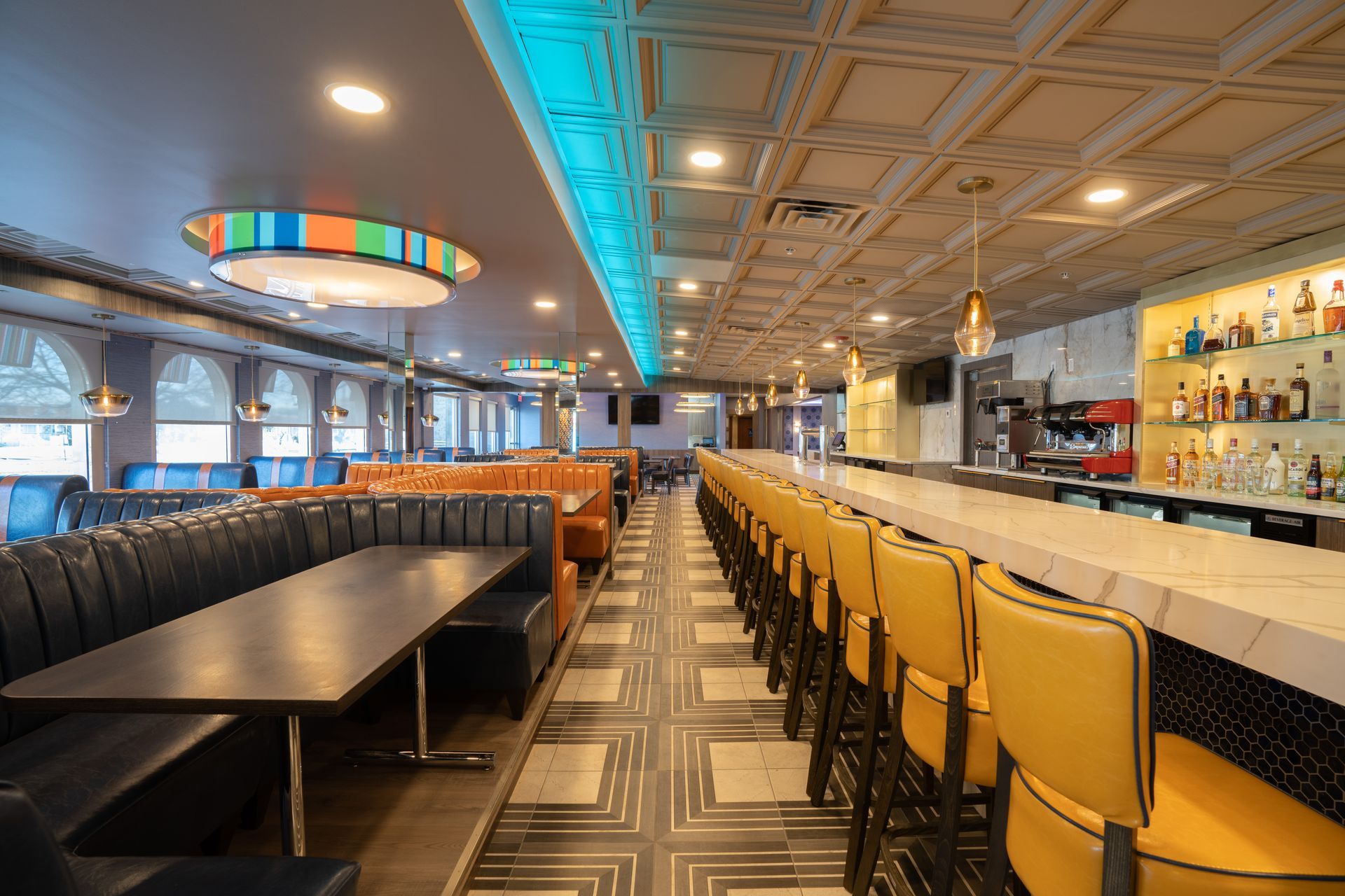 A diner with tables and chairs and a long bar.