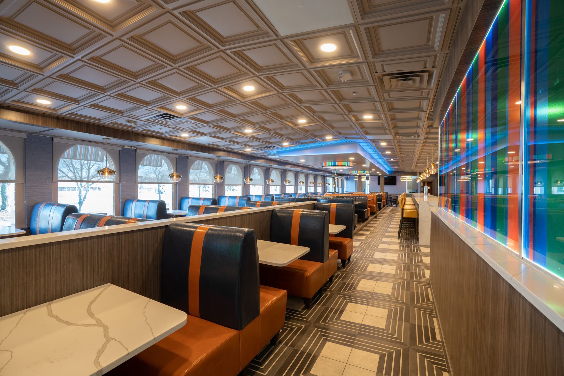 A long hallway with tables and benches in a diner.
