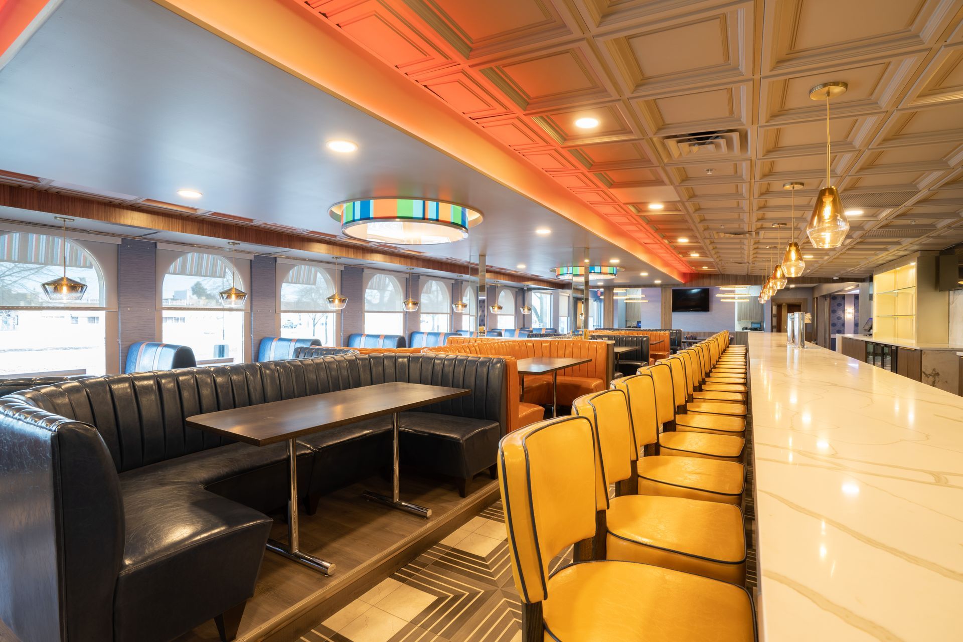 A diner with tables and chairs and a long bar.