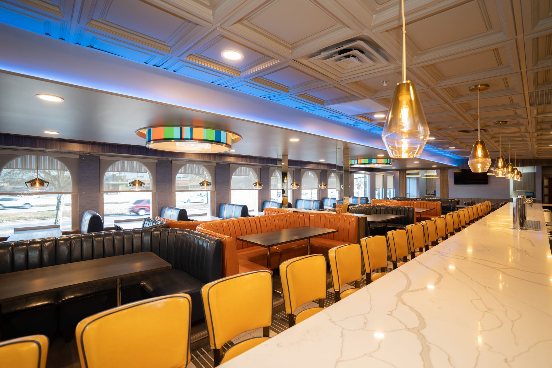 A diner with tables and chairs and a long bar.