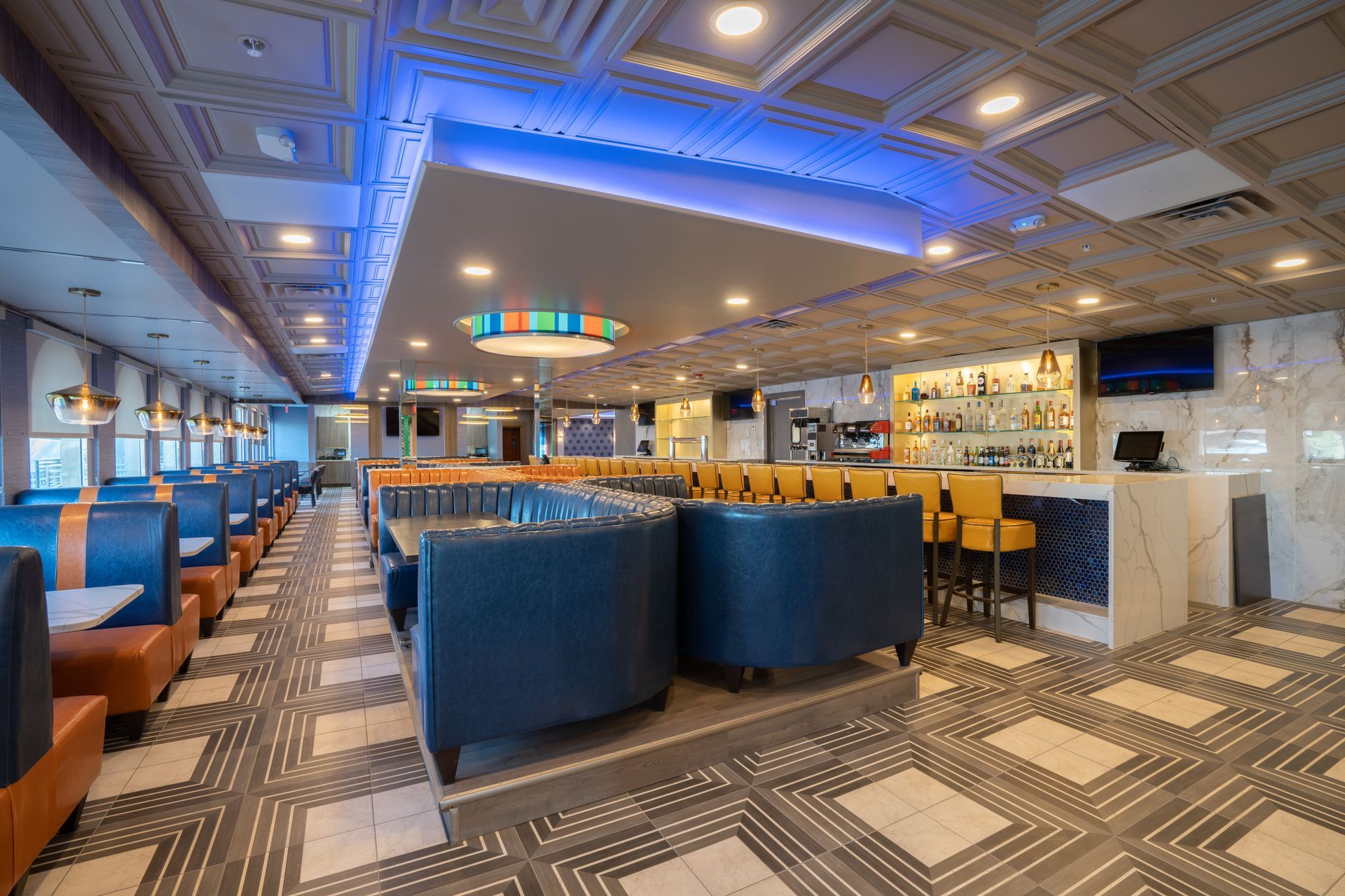 A diner with a lot of tables and chairs and a bar.