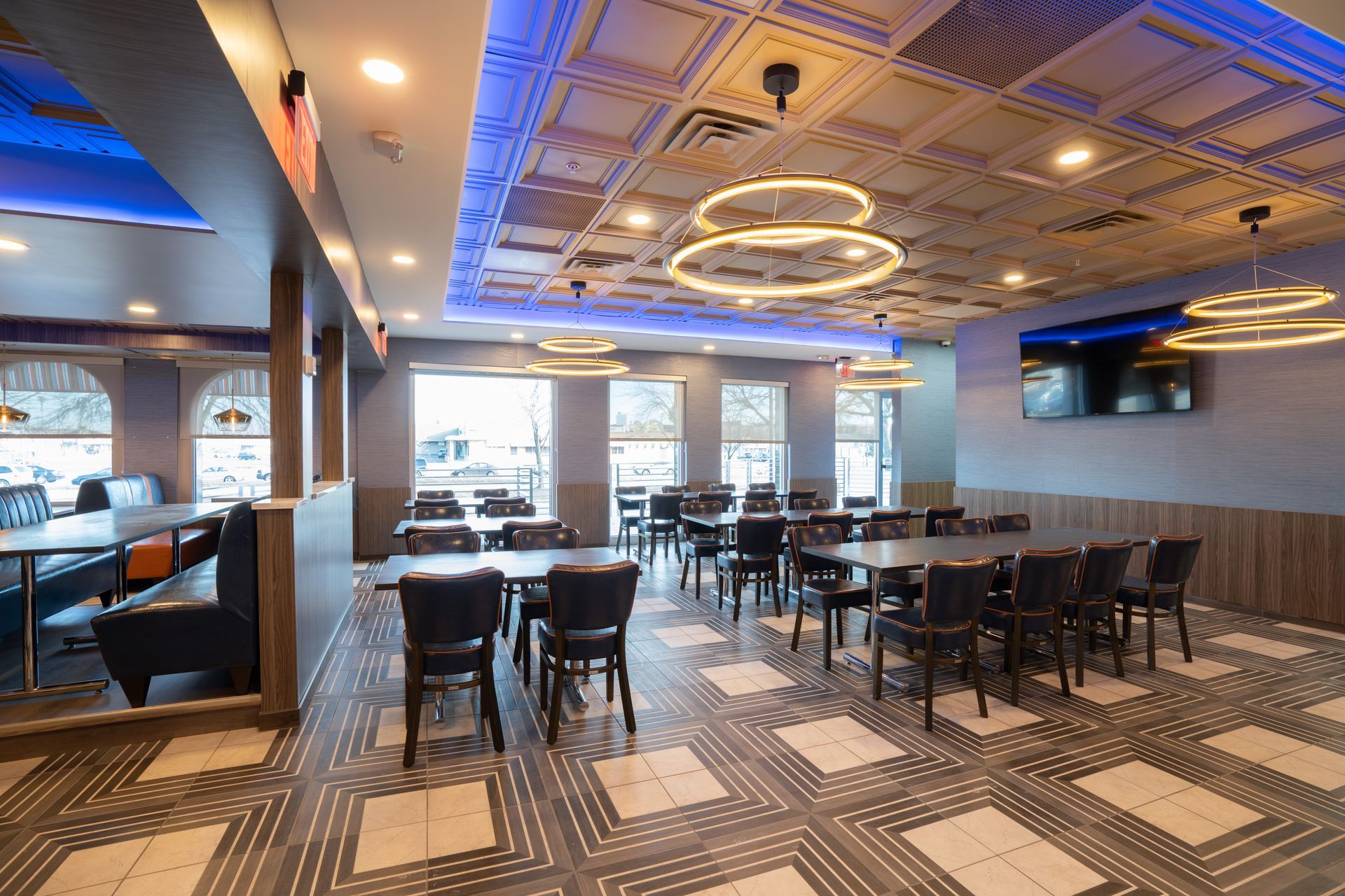 A large dining room with tables and chairs and a blue ceiling.