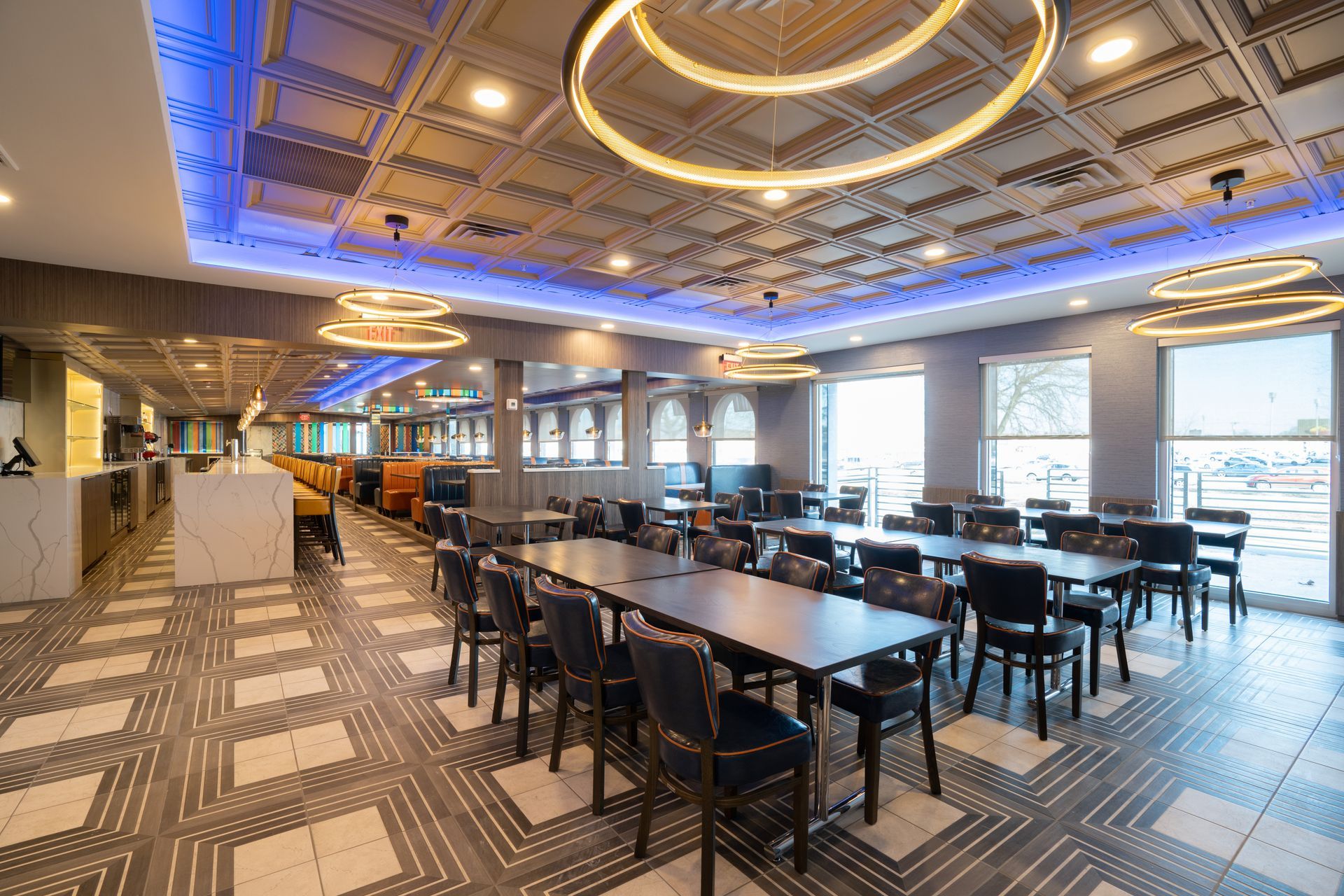 A large dining room with tables and chairs and a blue ceiling.