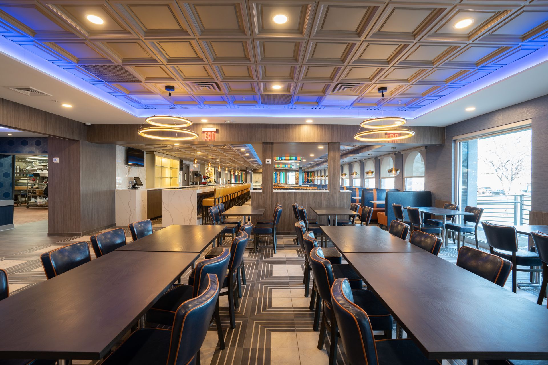 A large dining room with tables and chairs and a blue ceiling.