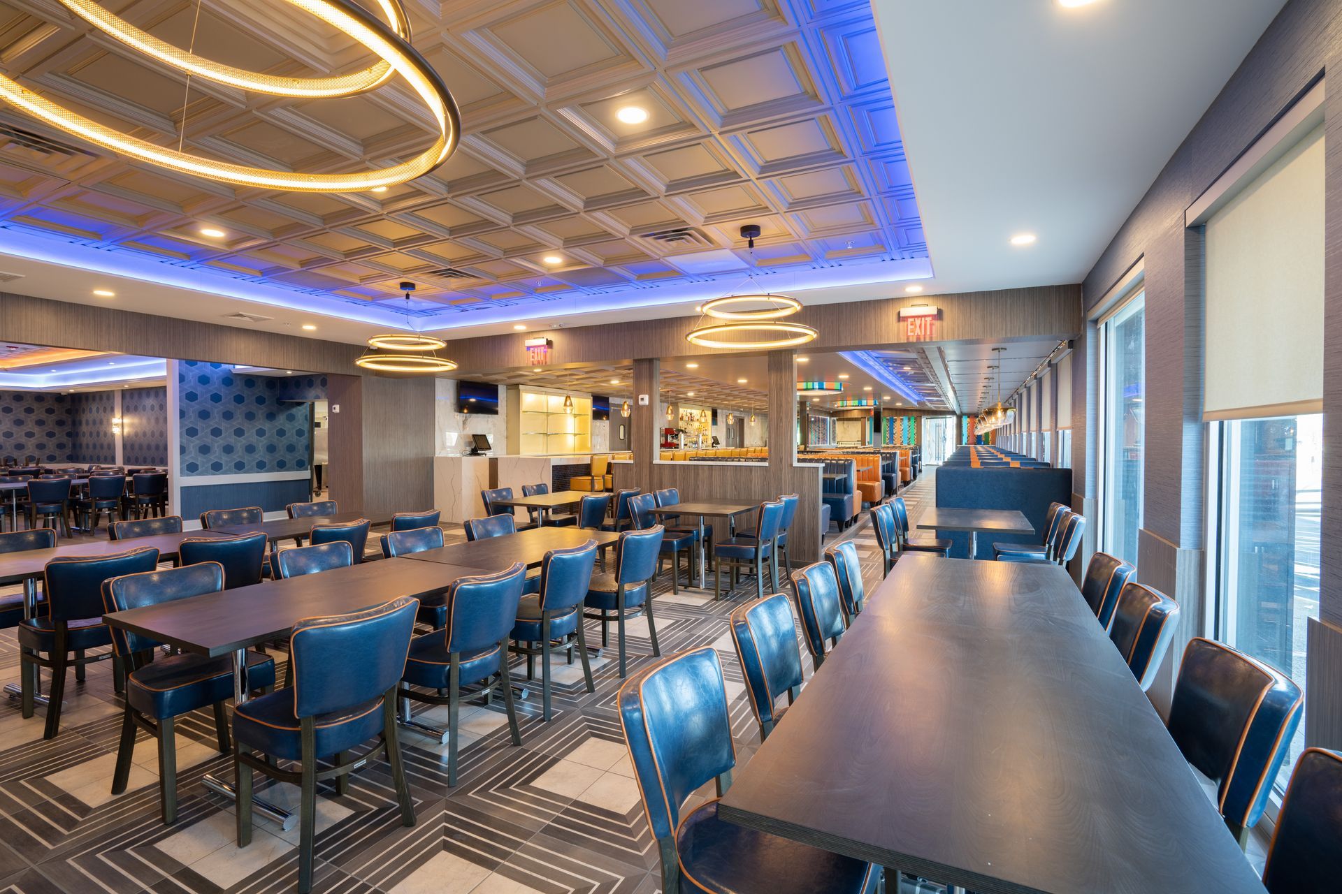 A large dining room with tables and chairs and a blue ceiling.