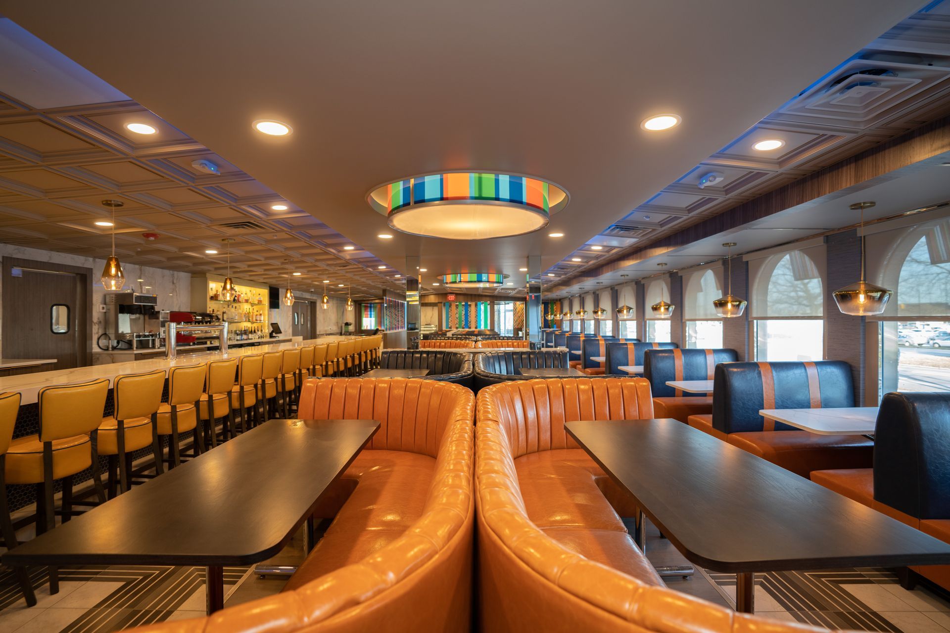 A restaurant with tables and chairs and a chandelier hanging from the ceiling.