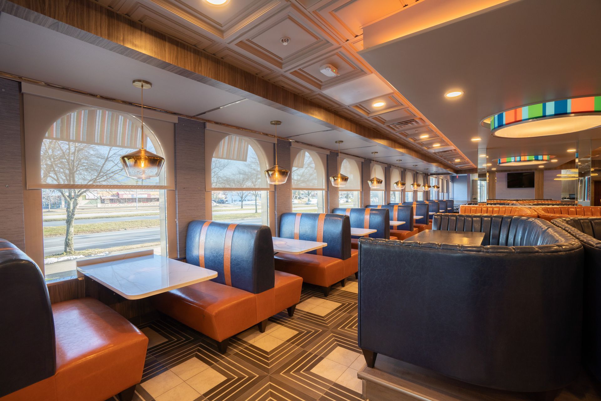 A diner with tables and chairs and a ceiling light.