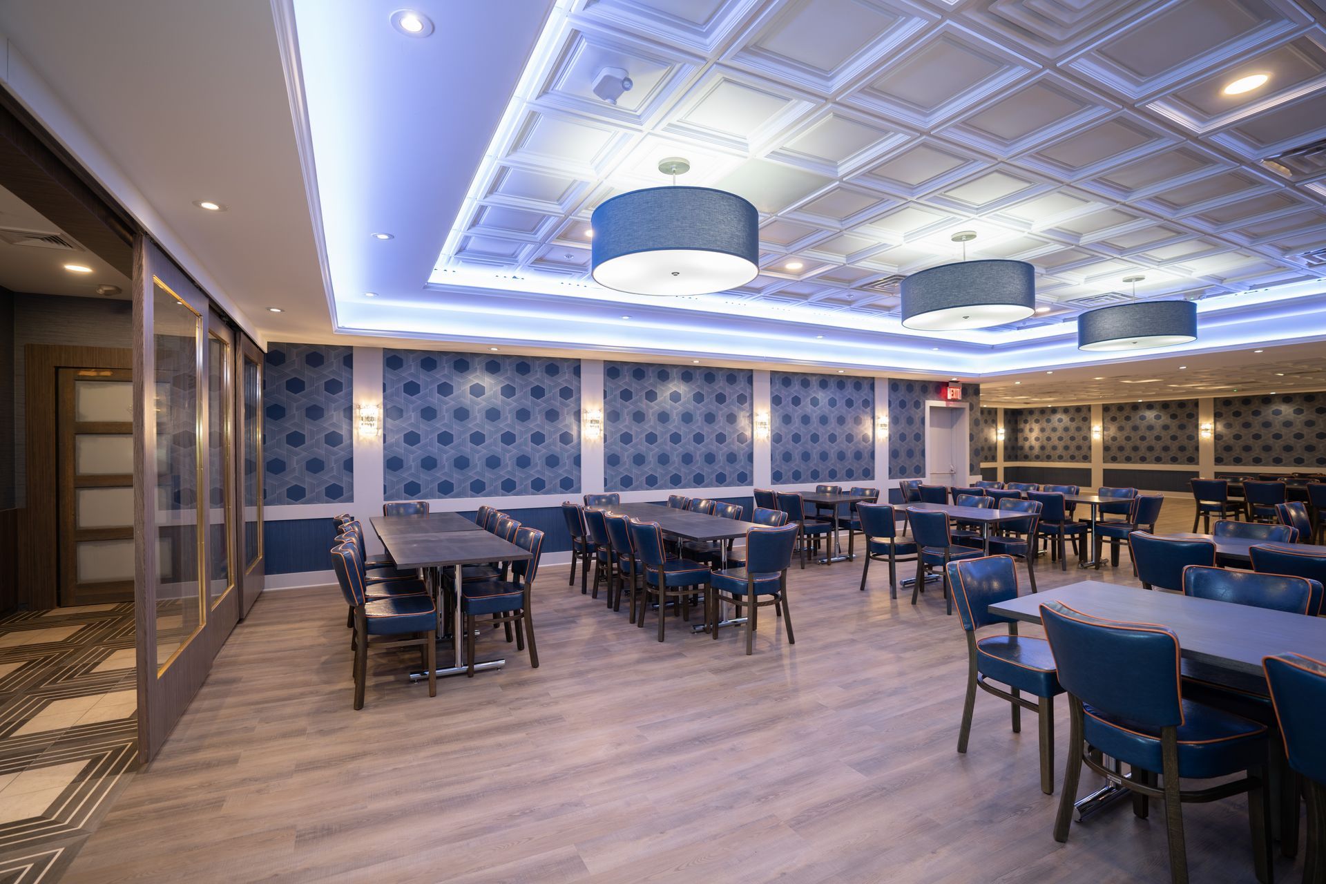 A large dining room with tables and chairs and a blue ceiling.