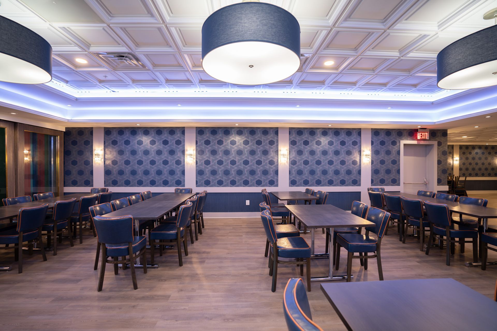 A large dining room with tables and chairs and a blue ceiling.
