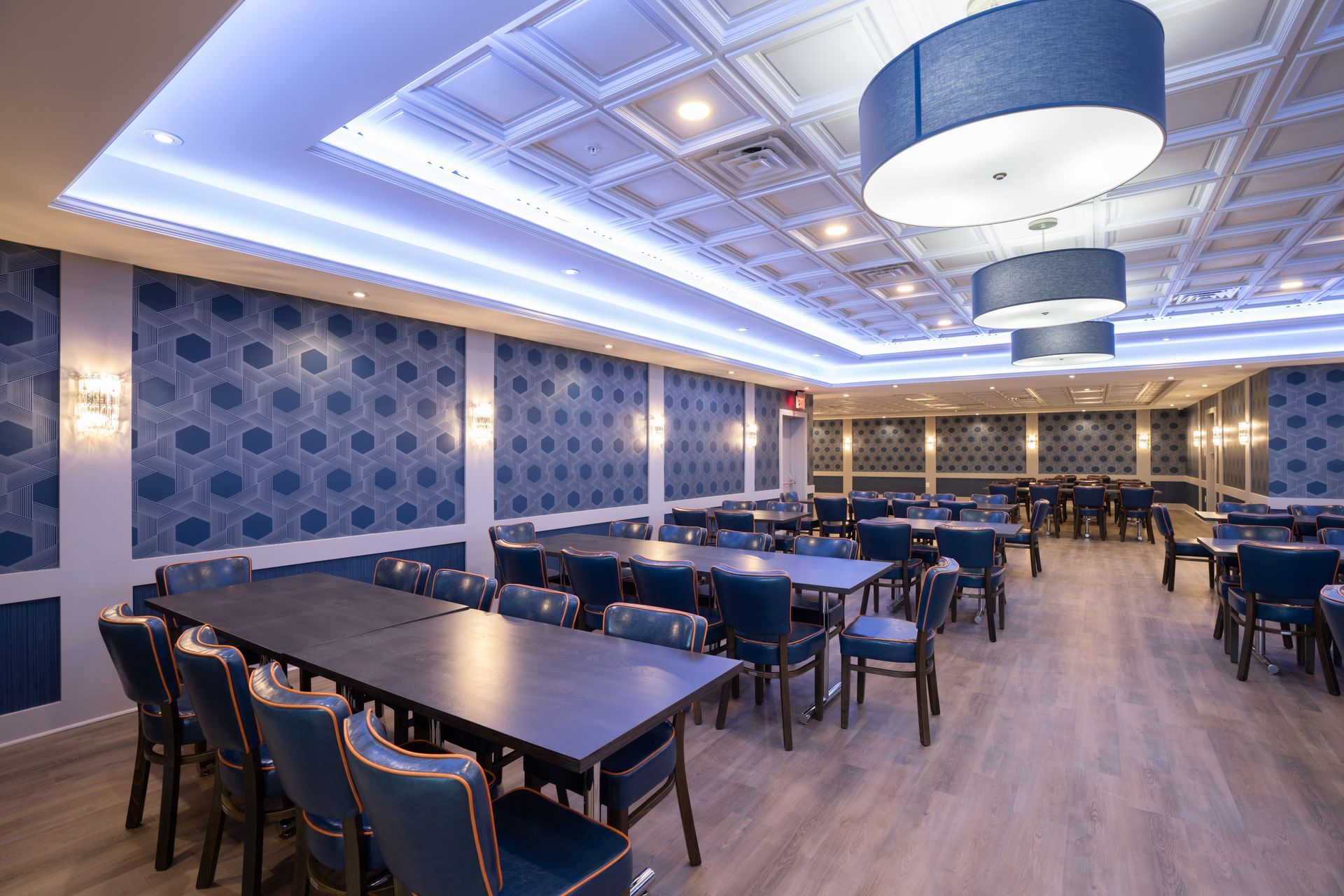 A large dining room with tables and chairs and a blue ceiling.