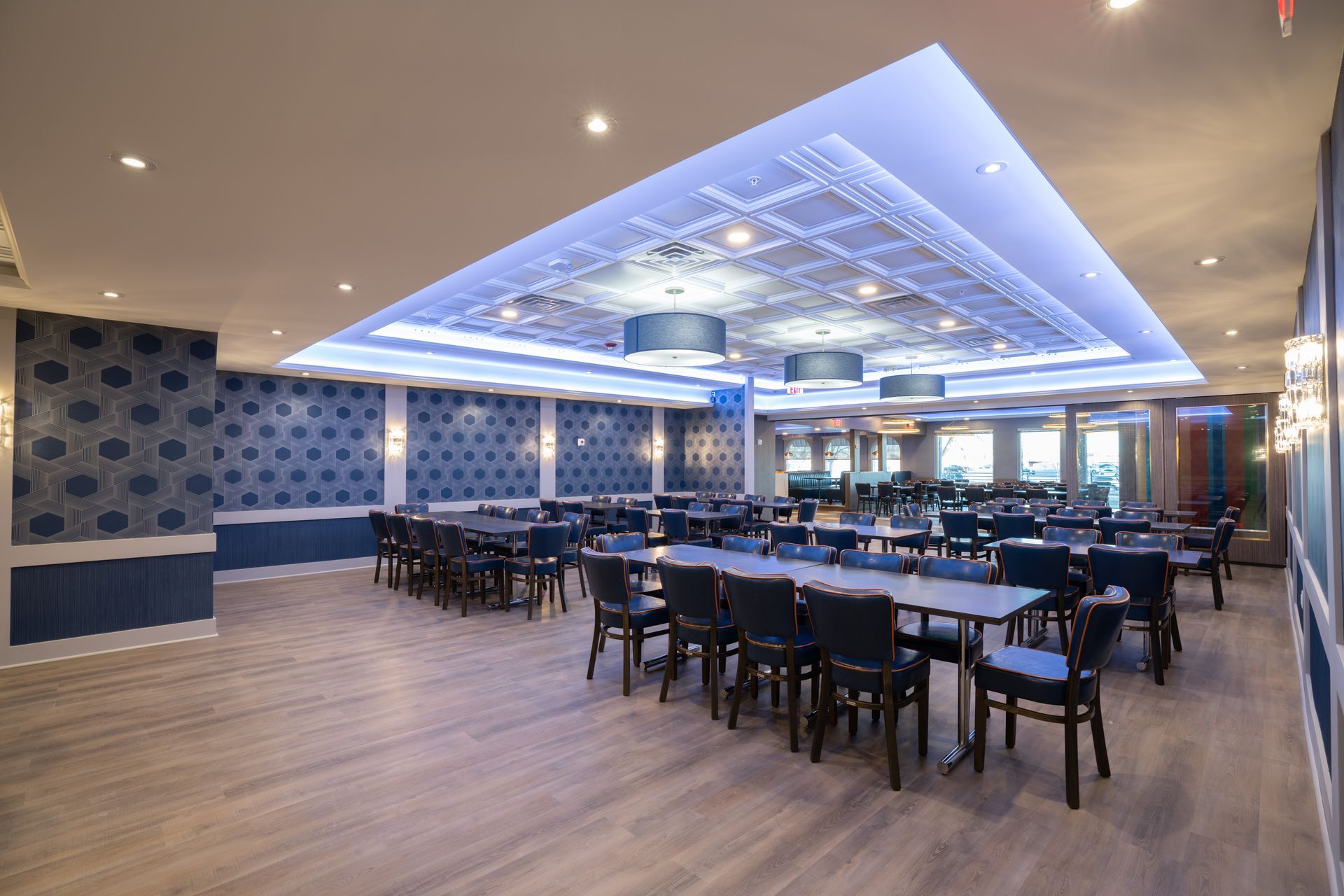 A large dining room with tables and chairs and a blue ceiling.