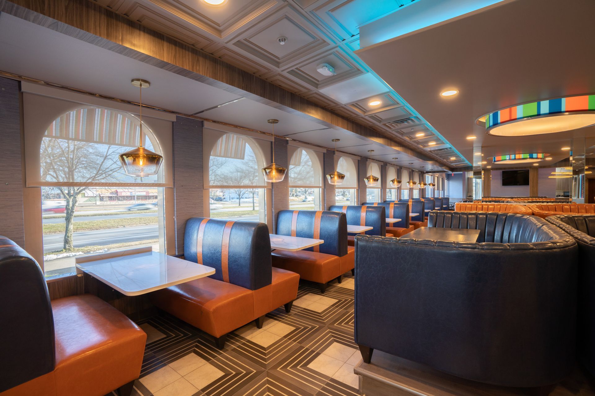 A diner with tables and chairs and a lot of windows.