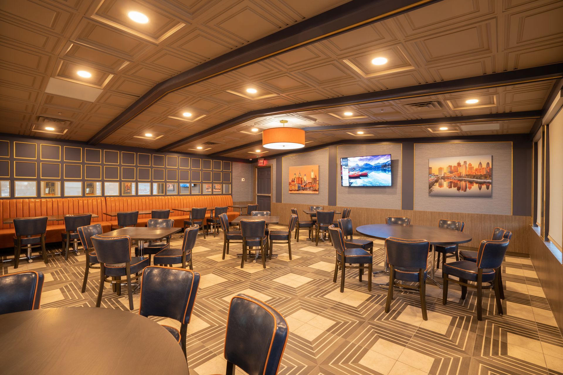 A large dining room with tables and chairs and a television on the wall.