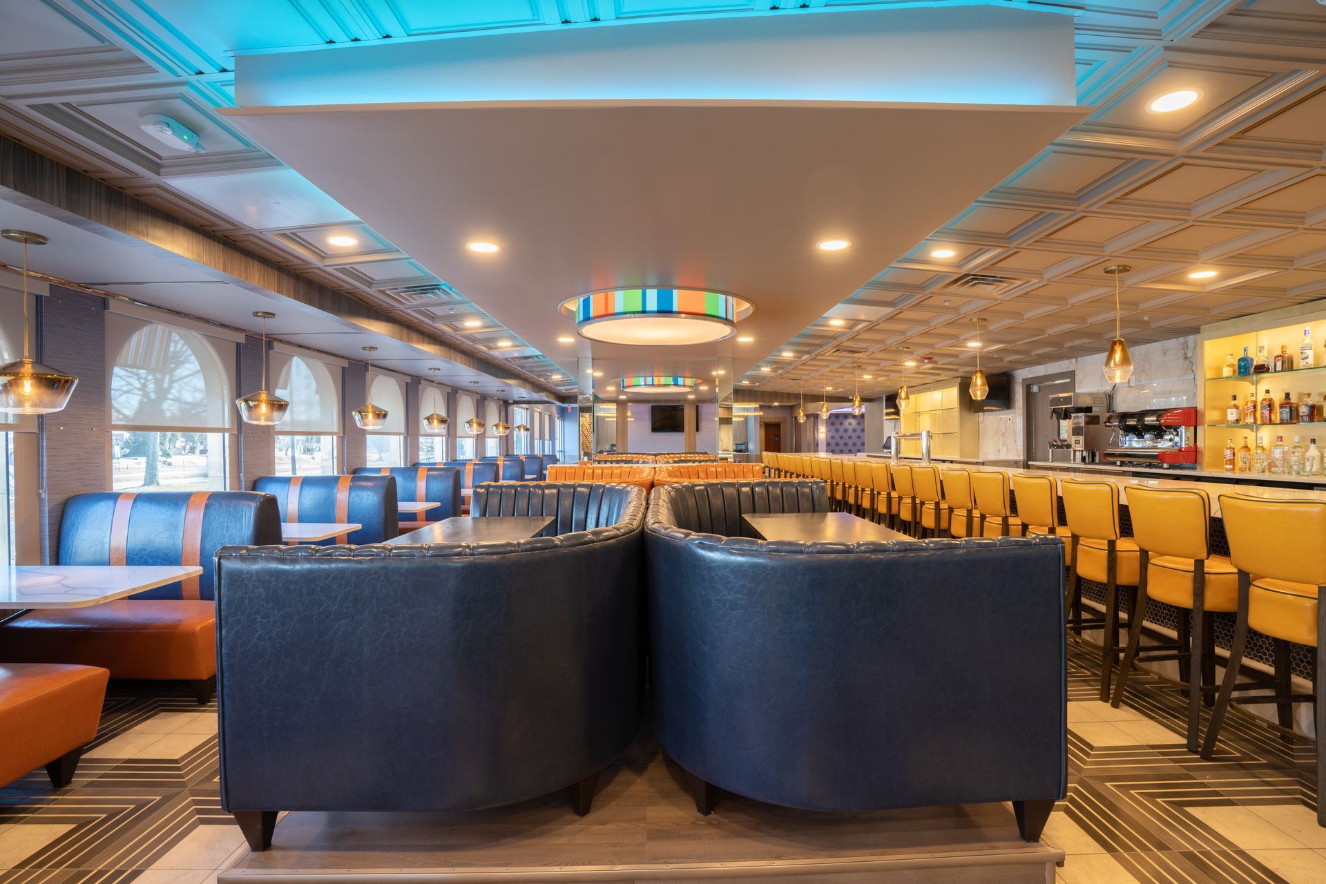 A restaurant with a lot of tables and chairs and a ceiling light.