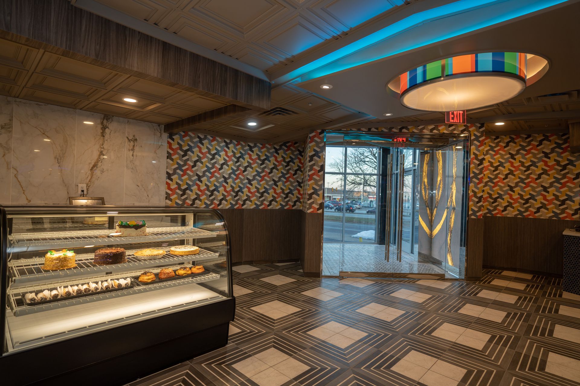 A room with a display case filled with food and a ceiling light.