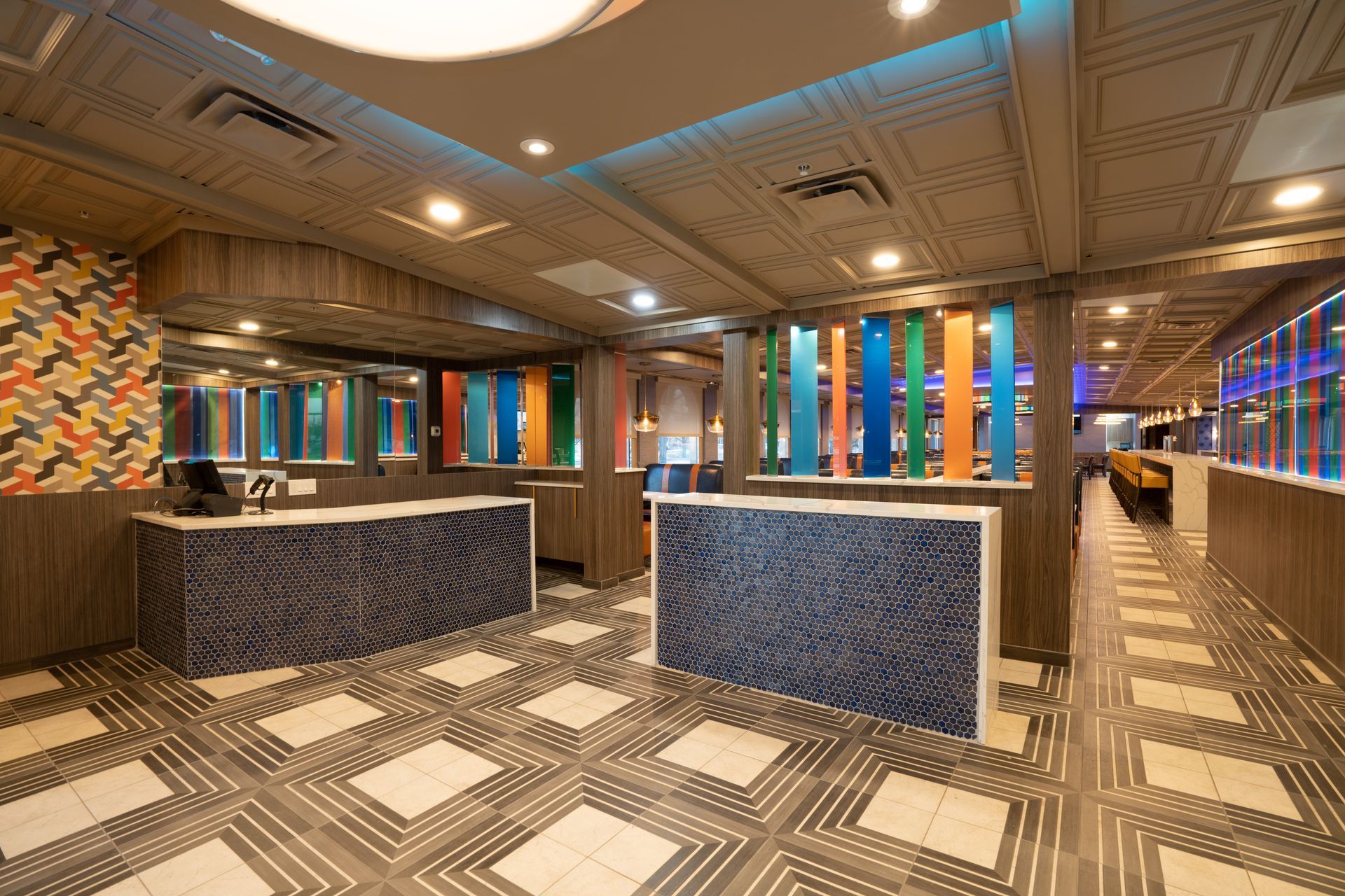 A hotel lobby with a colorful ceiling and a checkered floor.