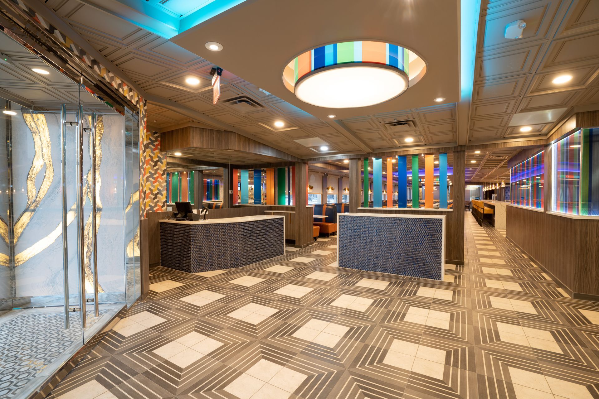 A large lobby with a colorful ceiling and a checkered floor.
