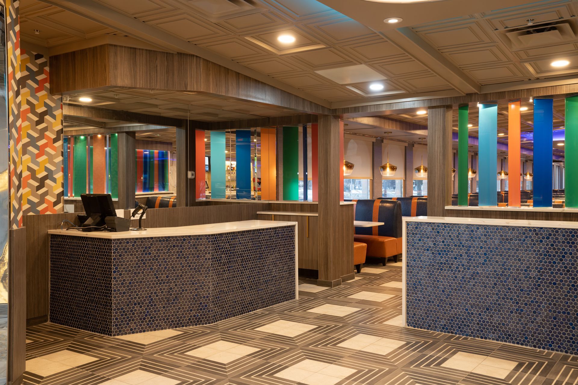 A restaurant with a checkered floor , tables , chairs and a counter.