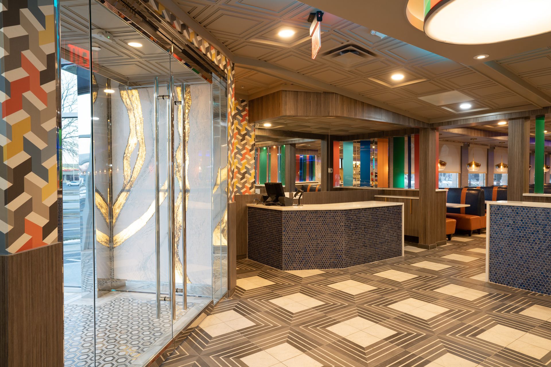 A restaurant with a checkered floor and a counter in the middle of the room.