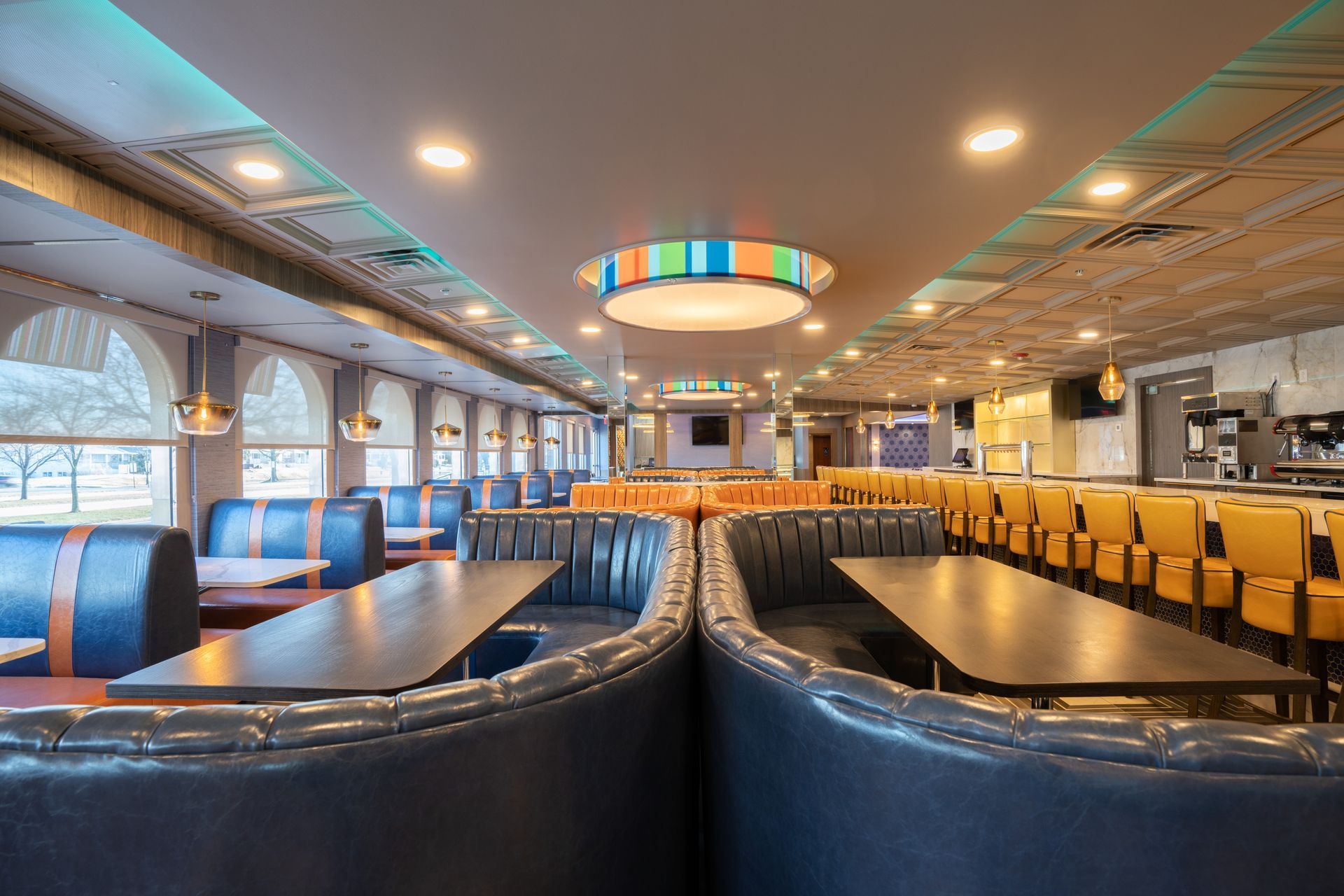 A restaurant with tables and chairs and a ceiling light.