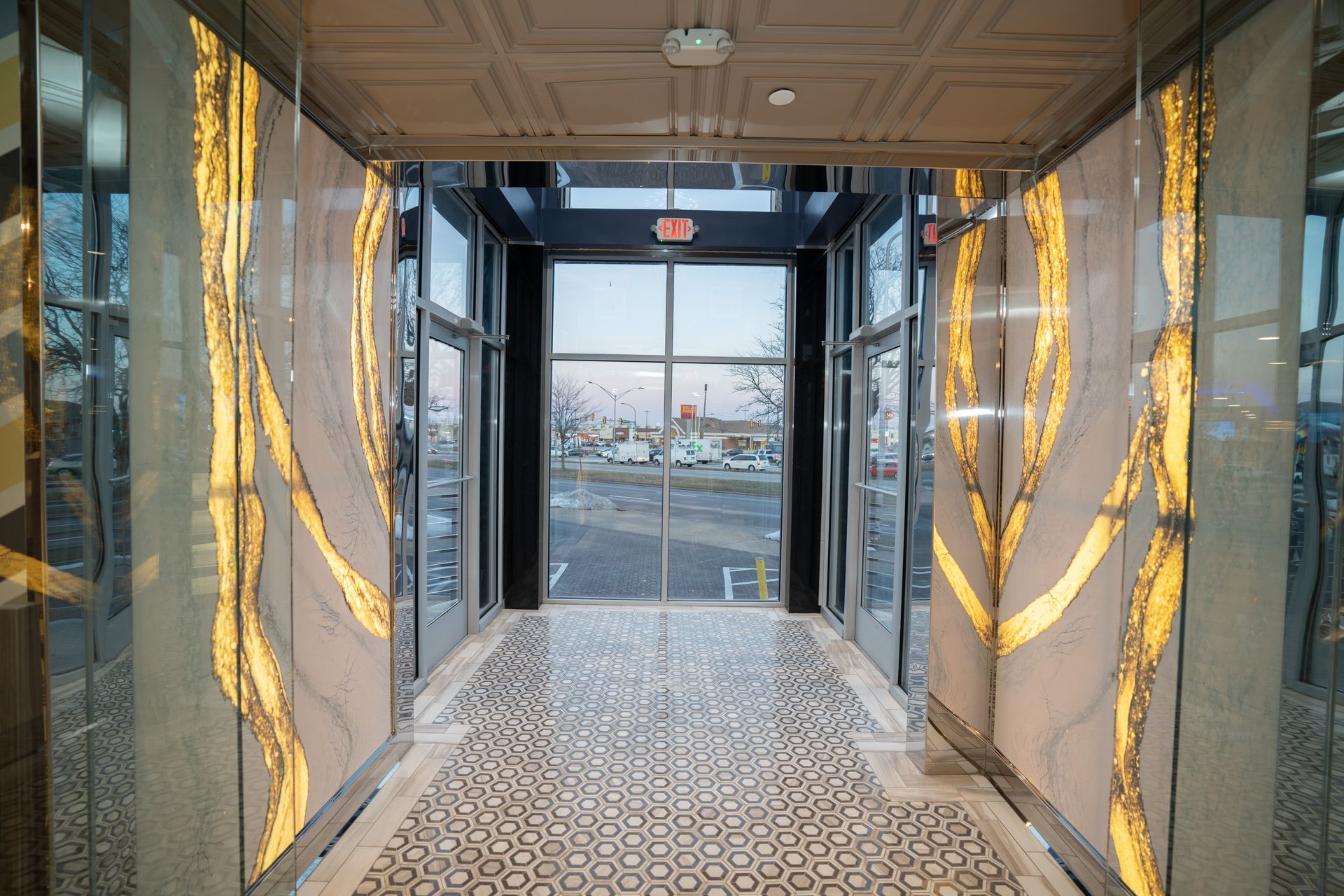 A long hallway with a lot of windows and a tiled floor.