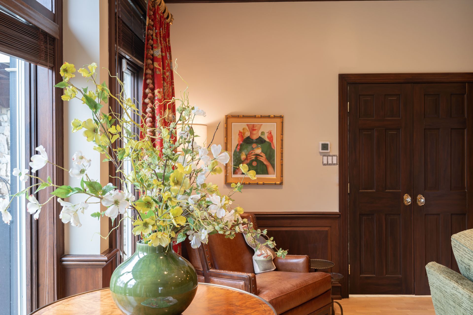 A vase of flowers is on a table in a living room.