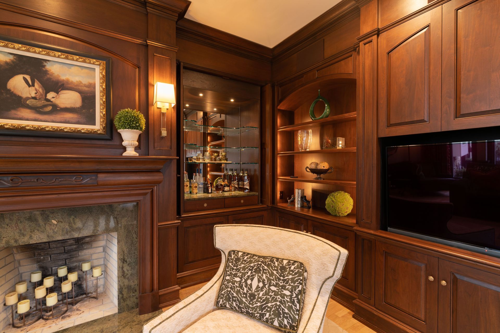 A living room with a fireplace , chair and television.