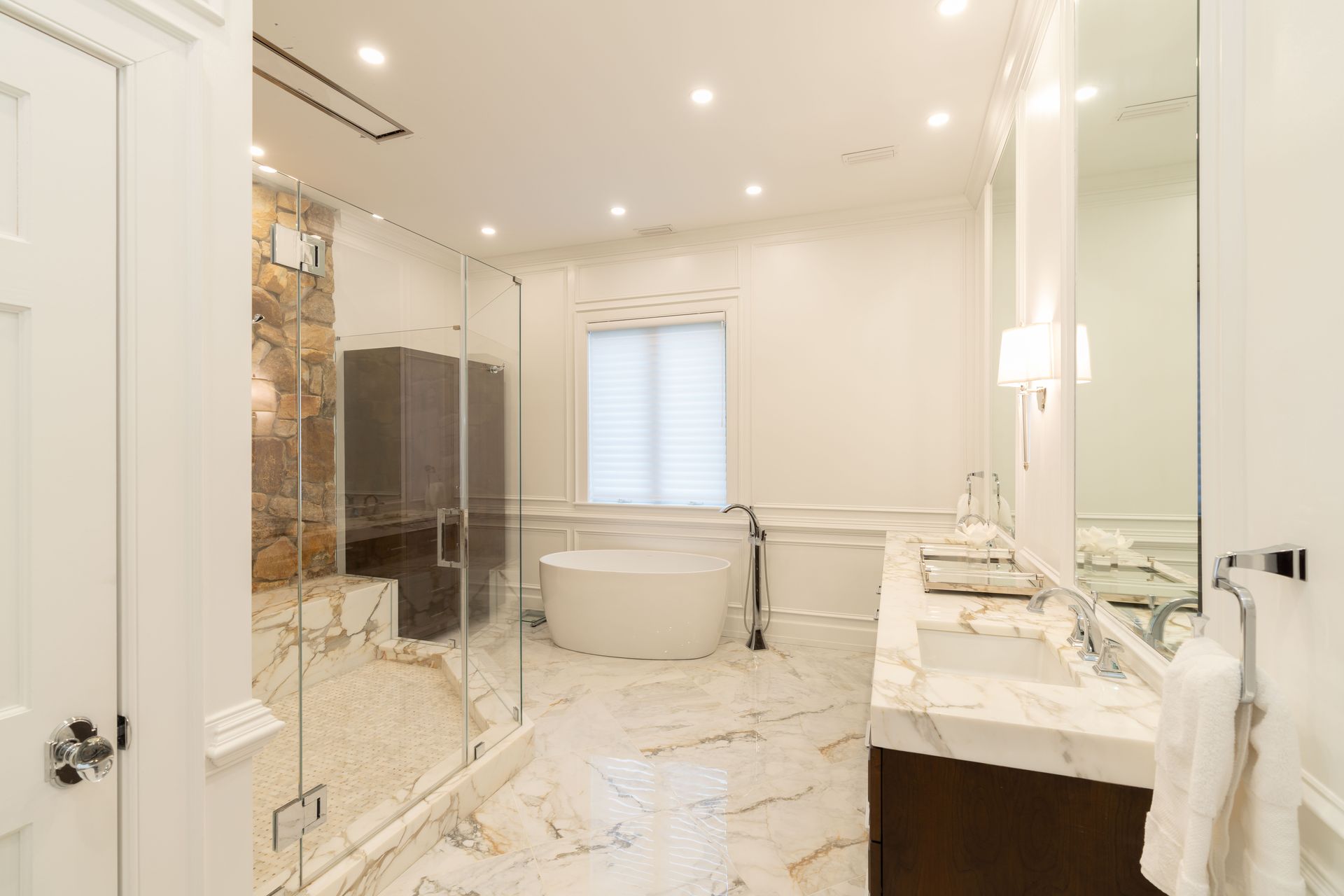A bathroom with two sinks , a tub , and a walk in shower.