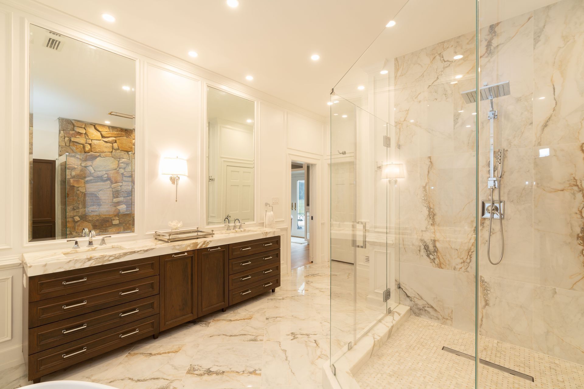 A bathroom with two sinks and a walk in shower.