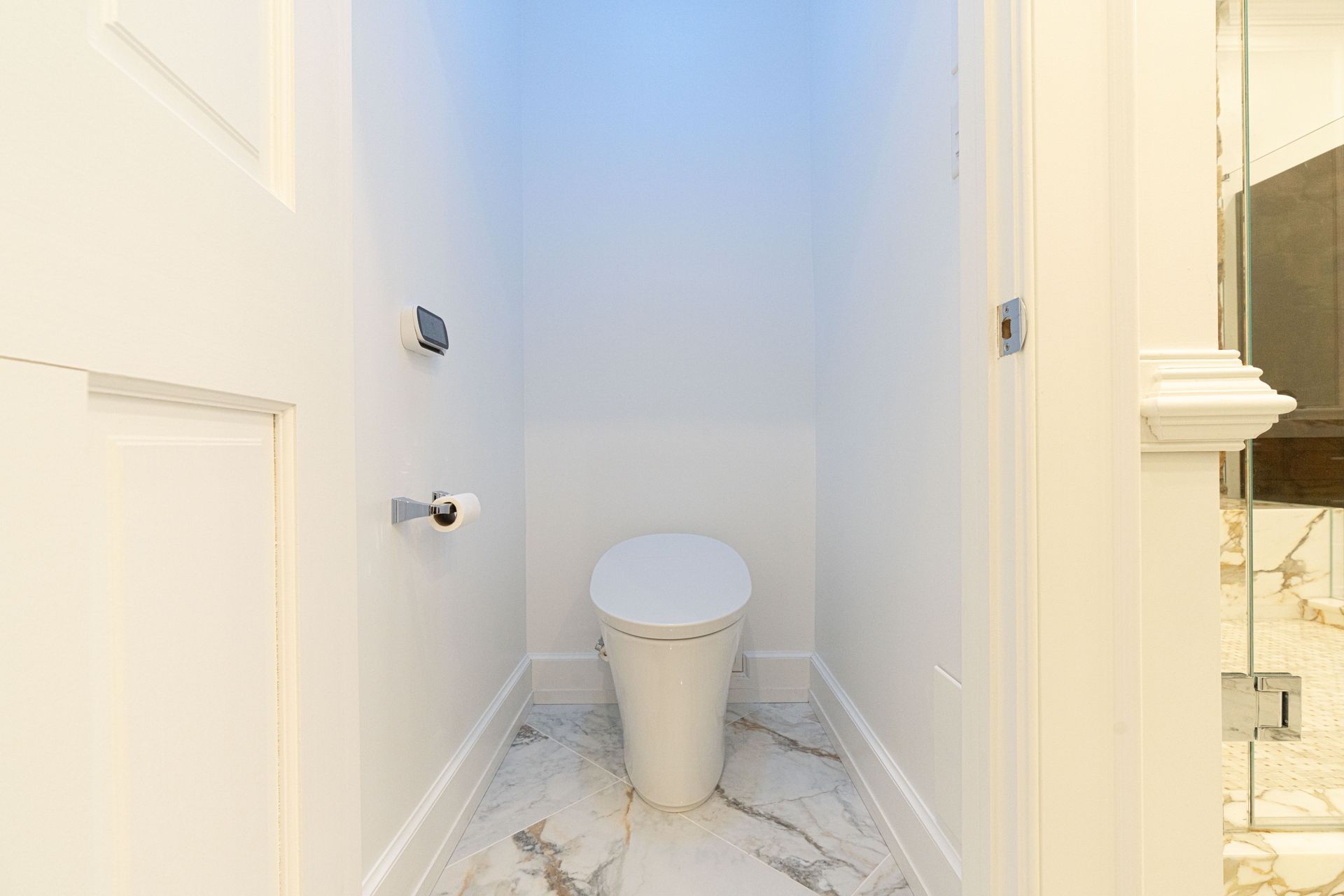 There is a toilet in the corner of a bathroom.