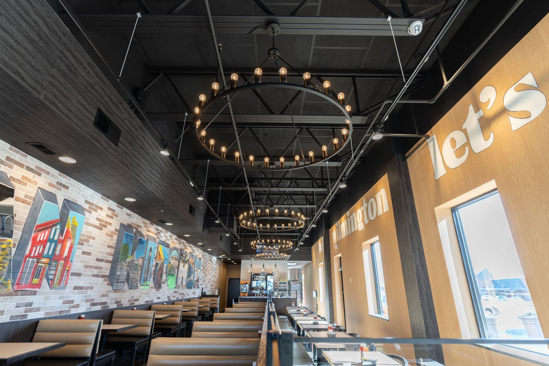 A restaurant with tables and chairs and a chandelier hanging from the ceiling.