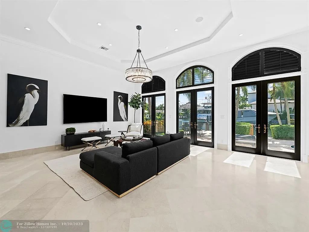 A living room with a black couch and a flat screen tv.