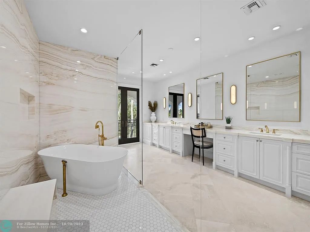 A bathroom with a bathtub , sinks , mirrors and a walk in shower.