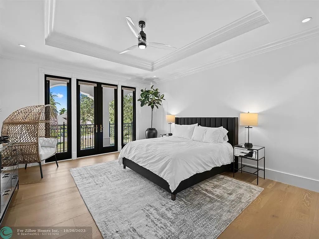 A bedroom with a large bed and a ceiling fan.