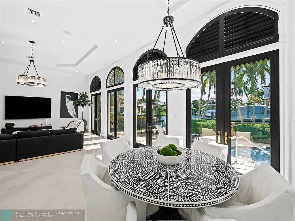 A living room with a dining table and chairs and a television.